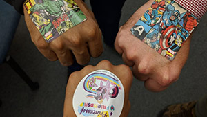 three fists together with colorful stickers on them