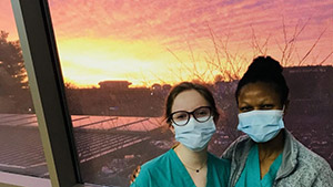 two people posing for a photo in front of a beautiful sunset