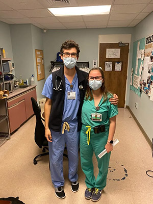 two people wearing PPE and posing for a photo