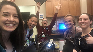 five people posing for a photo and laughing